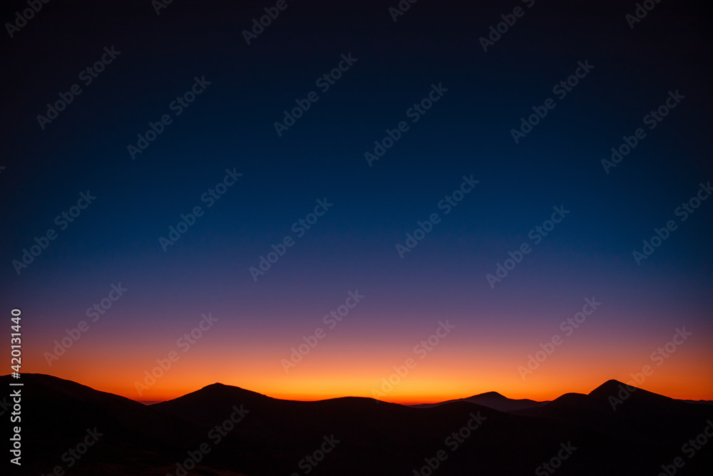 Obraz premium Silhouette of mountain peaks during summer sunset