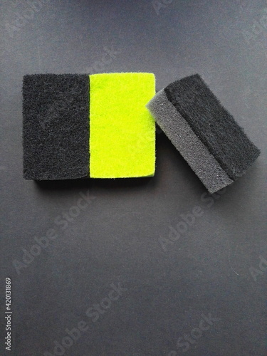 Three sponges on a black background. Yellow and black.