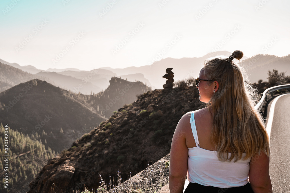 Beautiful blonde woman walking on mountains