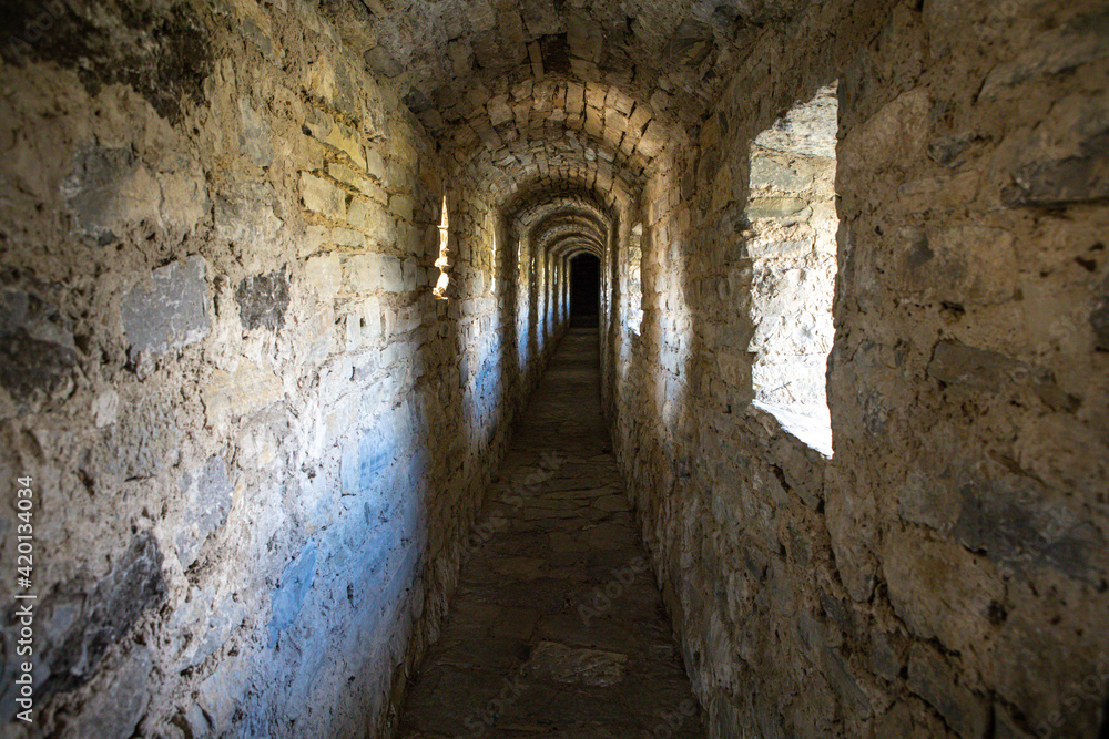 Old narrow warm stone tunnel in a medieval castle