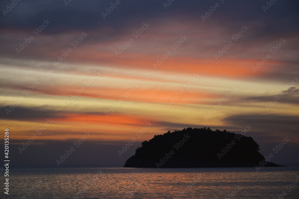 Silhouette of an island against a sunset sky