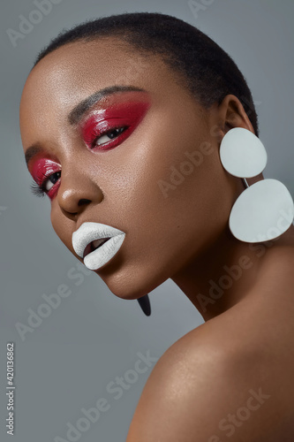 sensual african american dark skin woman looking at camera in red  eyeshadow and white lips