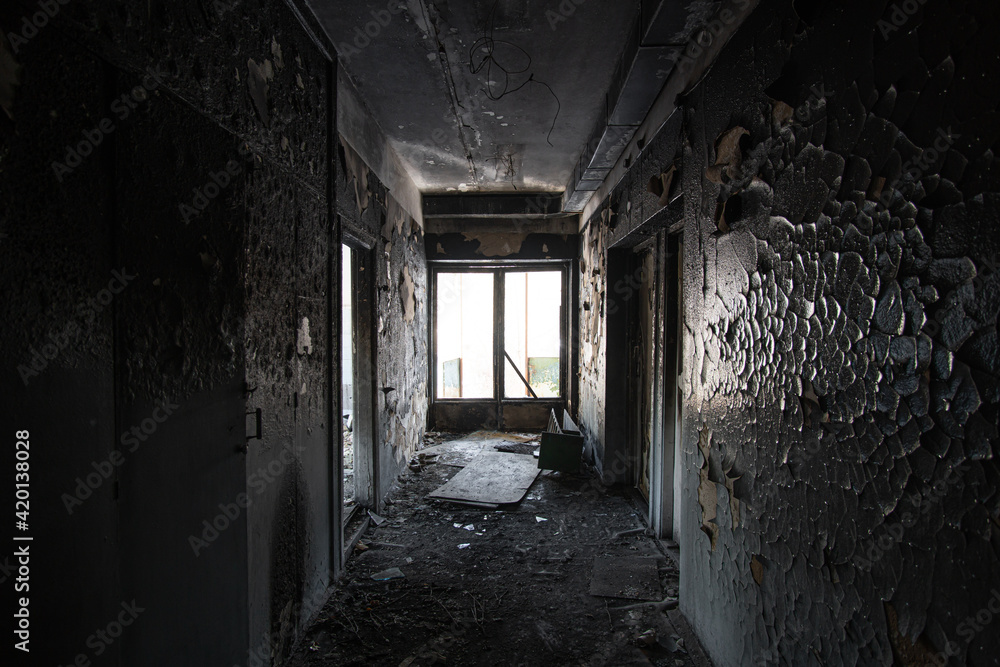 Corridor of the burned house where the fire took place with charred paint on the walls.