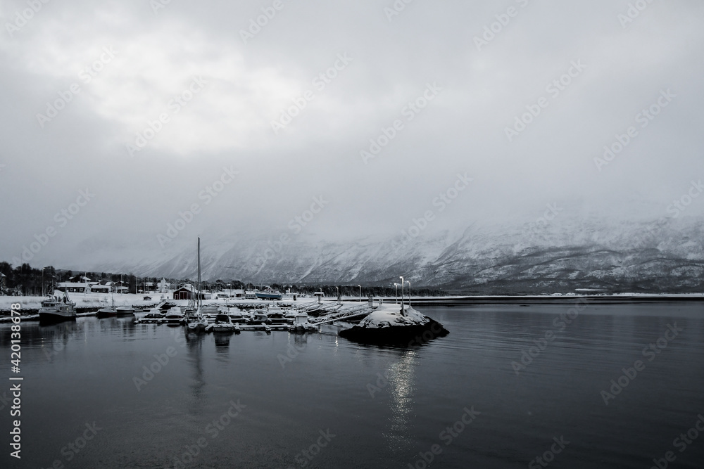 Boats in the arctic snowy harbor in Yykeanpera, Norway.