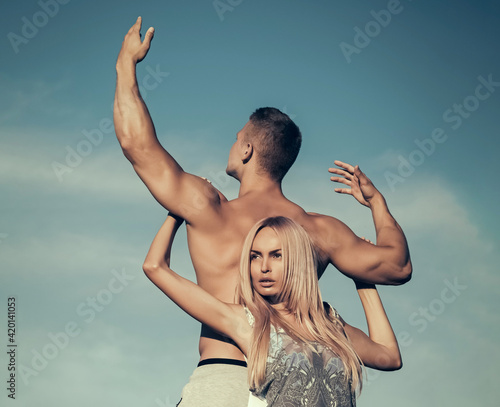 Couple fitness, sport and lifestyle. Tenderness and strength concept. Woman and man holding hands on blue sky.