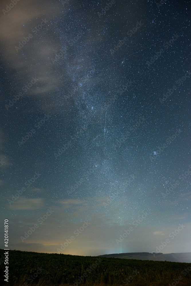 Night sky with stars and the Milky Way and meteor shower. Night landscape.