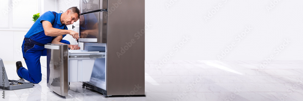 Serviceman Repairing Refrigerator Serviceman Repairing Refrigerator