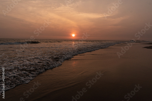 Krajobraz zachodu słońca nad brzegiem oceanu, plaża i nastrojowy widok.