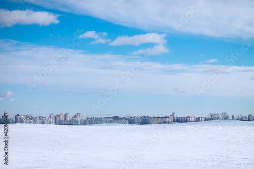 Landscape of urban high-rise buildings on background of blue sky and white snow © Евгения Рубцова