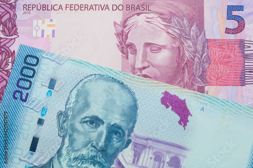 A macro image of a pink and purple five real bank note from Brazil paired up with a colorful two thousand colones bank note from Costa Rica.  Shot close up in macro. photo