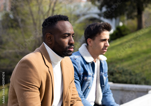 Two men looking serious and pensive. Afro-american and caucasian man.