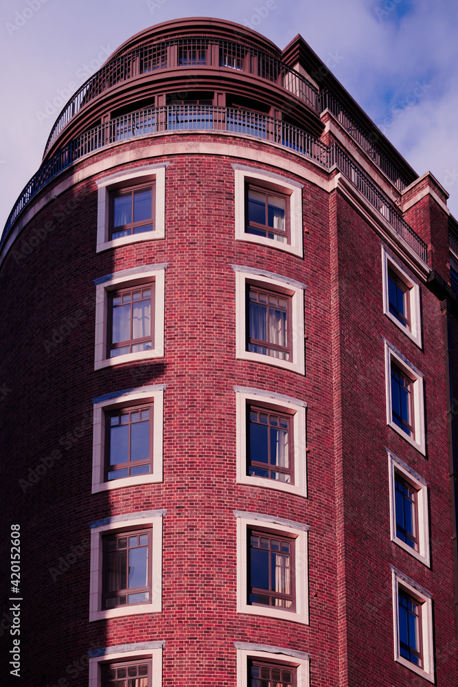 Looking up at modern red brick apartment building