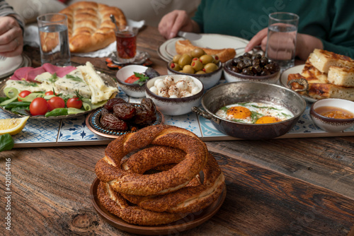 Delicious rich Traditional Turkish breakfast include tomatoes, cucumbers, cheese, butter, eggs, honey, bread, bagels, olives and tea cups. Ramadan Suhoor aka Sahur (morning meal before fasting). 