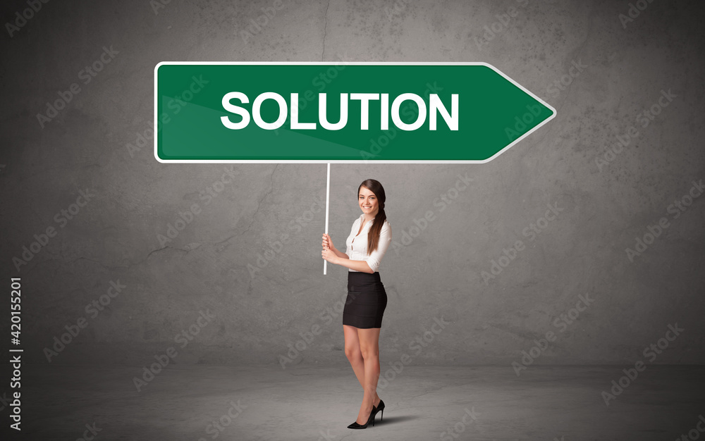 Young business person in casual holding road sign Young business person in casual holding road sign