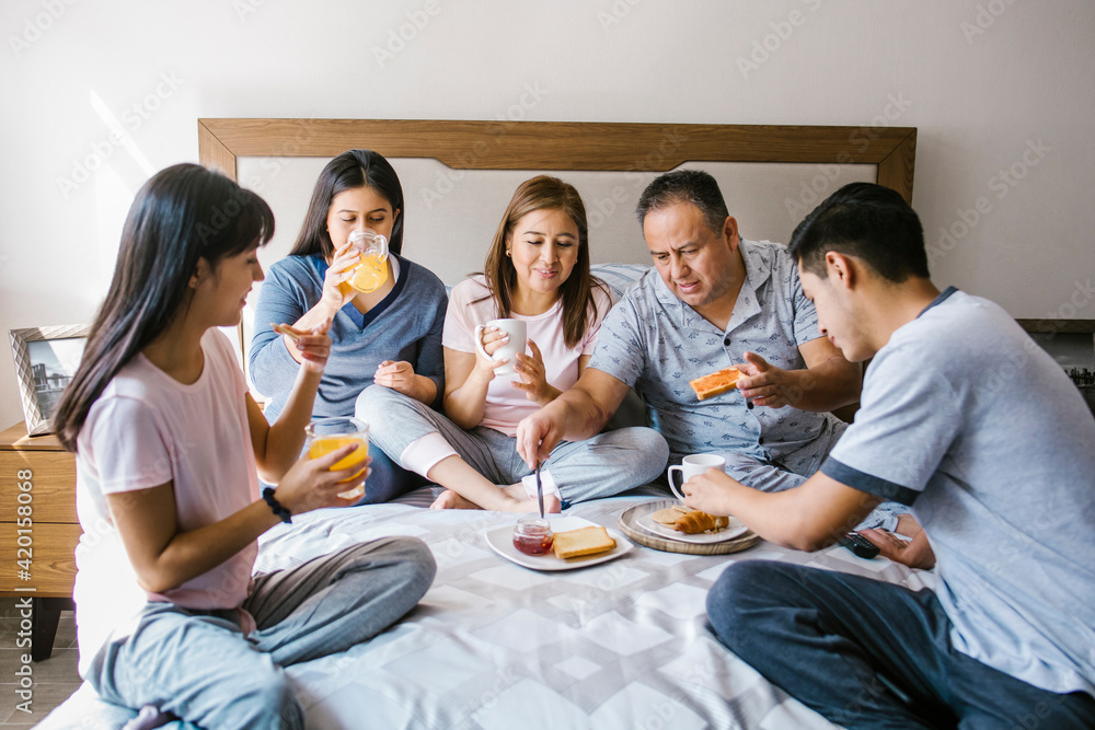 mexican Family having breakfast together in bed at home in Latin America mexican Family having breakfast together in bed at home in Latin America