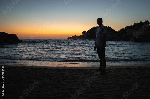 Hombre en la playa viendo el atardecer