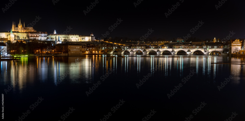 .view of the illuminated Prague Castle and the Cathedral of St. Vitus and Charles Bridge on the Vltava River at night in the center of Prague in the Czech Republic