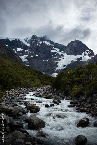 Beutiful mountains with a glaciar, a river and a green forest in a dramatic cloudy day