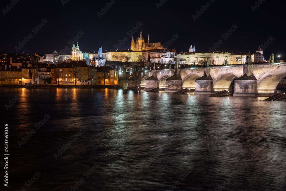 .view of the illuminated Prague Castle and the Cathedral of St. Vitus and Charles Bridge on the Vltava River at night in the center of Prague in the Czech Republic