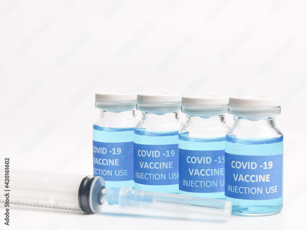 A row of COVID 19 VACCINES with syringe isolated on white background. Selective focus. A row of COVID 19 VACCINES with syringe isolated on white background. Selective focus.
