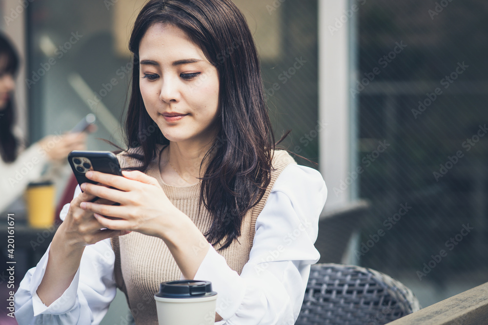 カフェでスマホを操作する若い女性 カフェでスマホを操作する若い女性