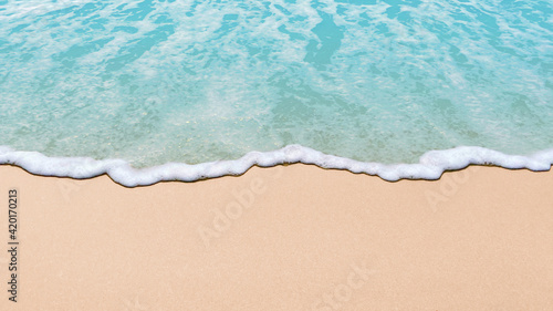 Soft blue ocean wave on clean sandy beach