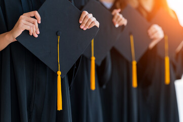 Close up group of graduates holding a hat At the graduation ceremony at the university