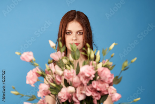 pretty woman with bouquets of flowers holiday womens day glamor blue background