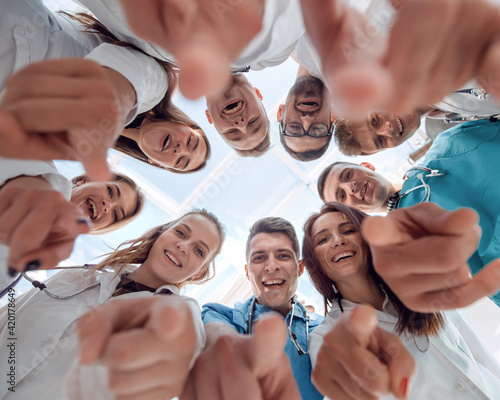 bottom view. diverse medical professionals pointing at you.