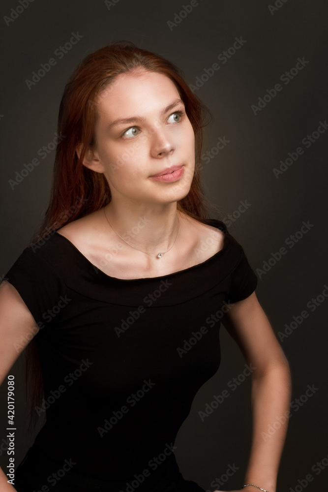 studio portrait of a young red-haired woman in black clothes studio portrait of a young red-haired woman in black clothes