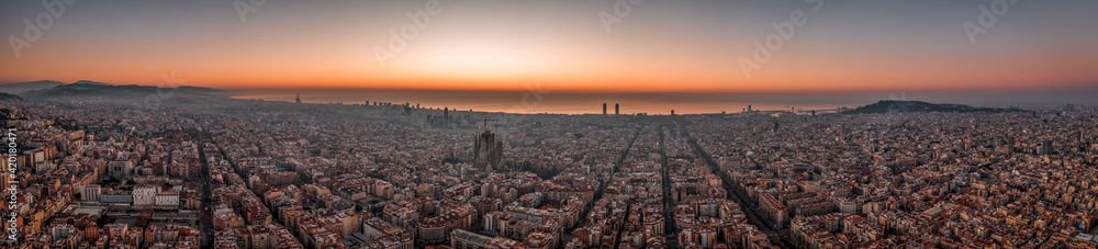 Aerial panorama drone shot of Barcelona with sunrise over sea horizon in Spain winter dawn