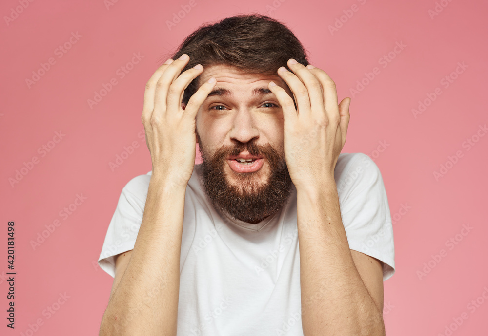 Portrait of a guy in a white t-shirt on a pink background cropped view of fun emotions Portrait of a guy in a white t-shirt on a pink background cropped view of fun emotions