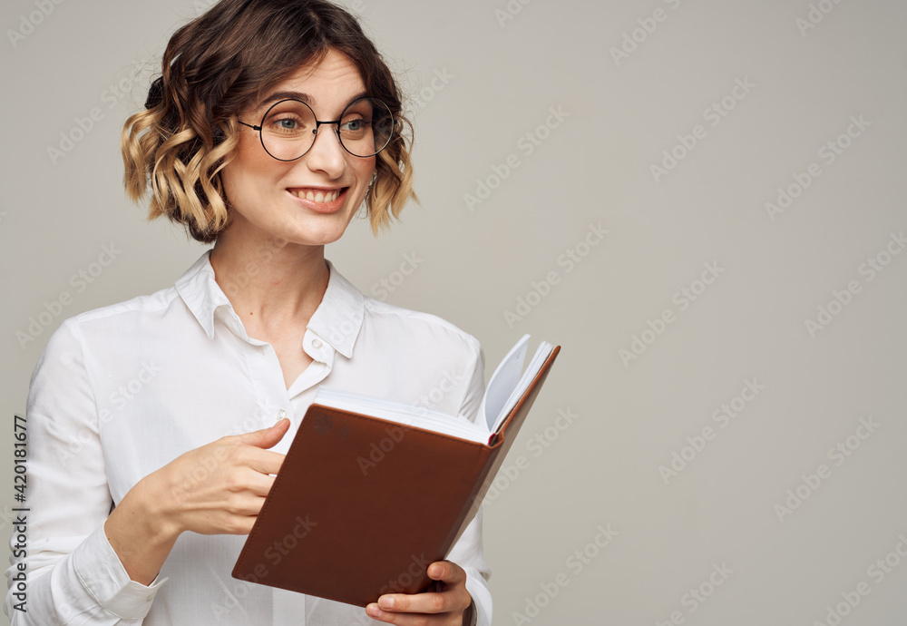 woman with notepad on gray background indoors gesturing with hands work office education woman with notepad on gray background indoors gesturing with hands work office education