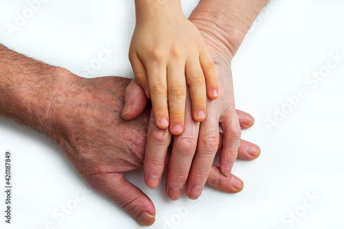 Little kids grandson hands on old hands of grandparents. Concept assistance, patronage and generation. National Senior Citizens Day. World Humanitarian Day.
