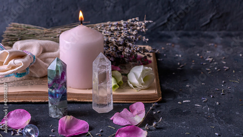 Magic still life with fluorite, quartz crystal and pink candle. Magic rocks for mystic ritual, witchcraft Wiccan or spiritual practice (healing). Meditation reiki. Ritual for love and chakra balance. photo