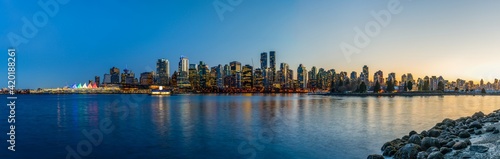 Night view of Vancouver downtown skyline panorama after sunset. Colorful buildings lights reflections on waterfront harbor. British Columbia  Canada.