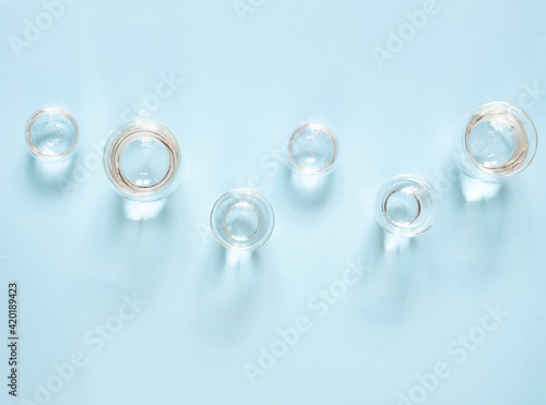 Water in double-walled glasses on a blue background. Top view