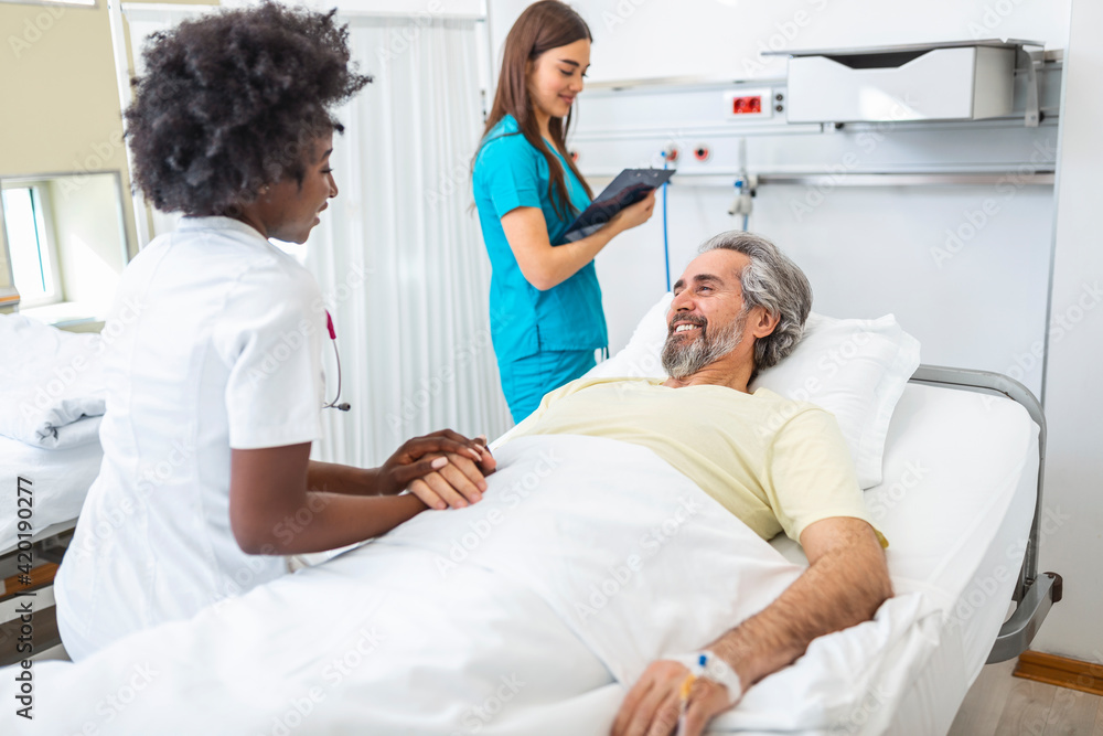 Obraz premium Healthcare concept of professional doctor consulting and comforting elderly patient in hospital bed or counsel diagnosis health. Medical doctor or nurse holding senior patient hands and comforting him