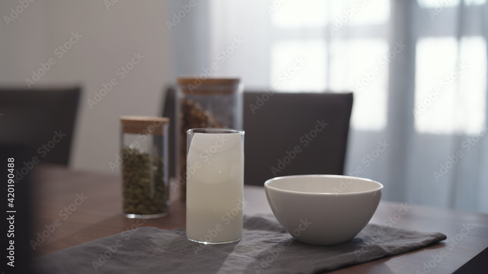 serving chocolate granola pour in white bowl on walnut table serving chocolate granola pour in white bowl on walnut table