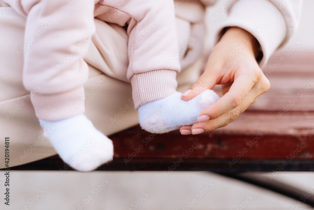 Baby's legs and mother's hands close up Baby's legs and mother's hands close up