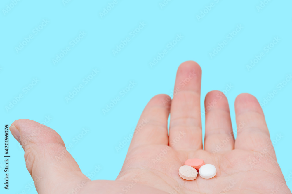 White and pink pills in the palm of your hand. Treatment with pills. White and pink pills in the palm of your hand. Treatment with pills.