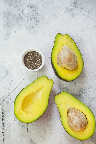 Sliced Avocado or Alpukat and a bowl of chia seed in textured-white background