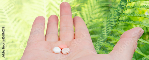 White and pink pills in the palm of your hand. Treatment with pills.