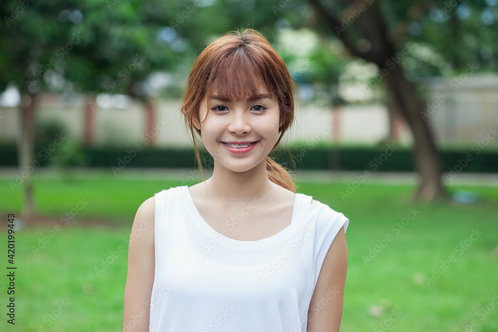 Beautiful smiling Asian woman looking at camera in public area. Beautiful smiling Asian woman looking at camera in public area.