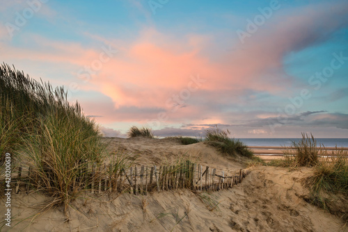 Beautiful sunrise over sand dunes system on yellow sand golden beach