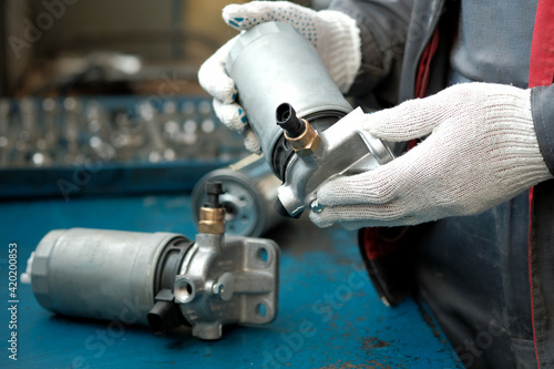 Fuel filter for diesel engine. Close-up. A mechanic checks the technical condition of the new fuel filter before replacing it.Car maintenance and repair.