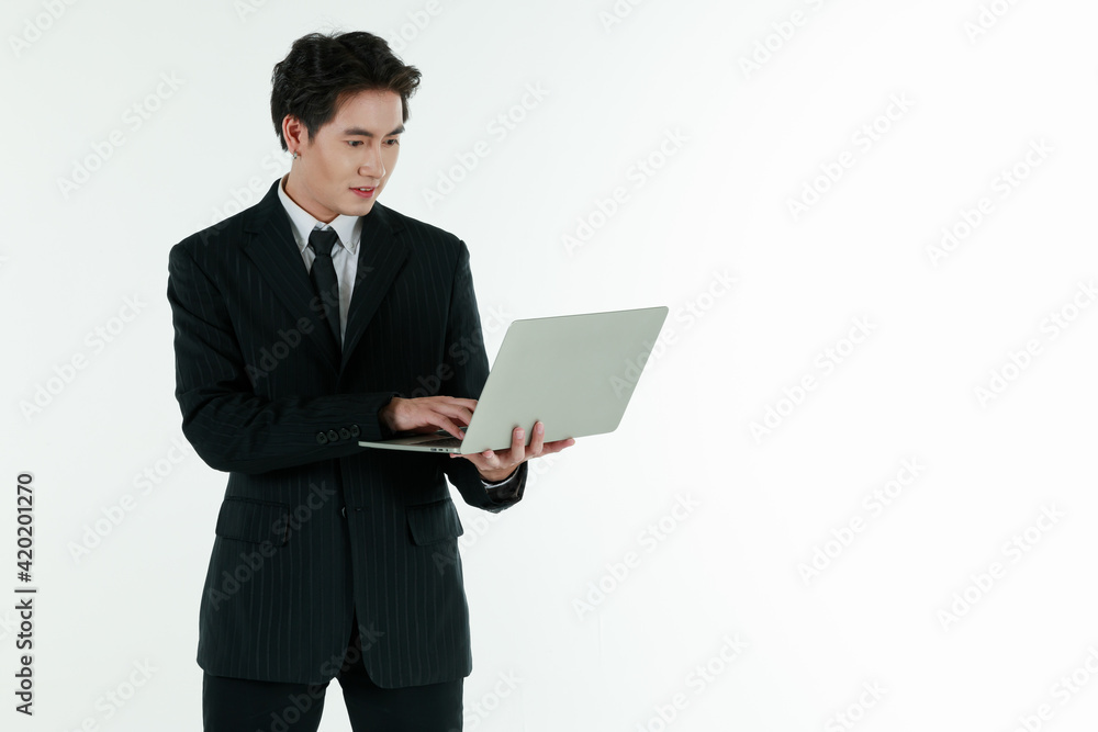 Portrait of self confidence young and handsome business Asian man in black suit holding notebook laptop computer with copy space studio shot isolated on white background Portrait of self confidence young and handsome business Asian man in black suit holding notebook laptop computer with copy space studio shot isolated on white background