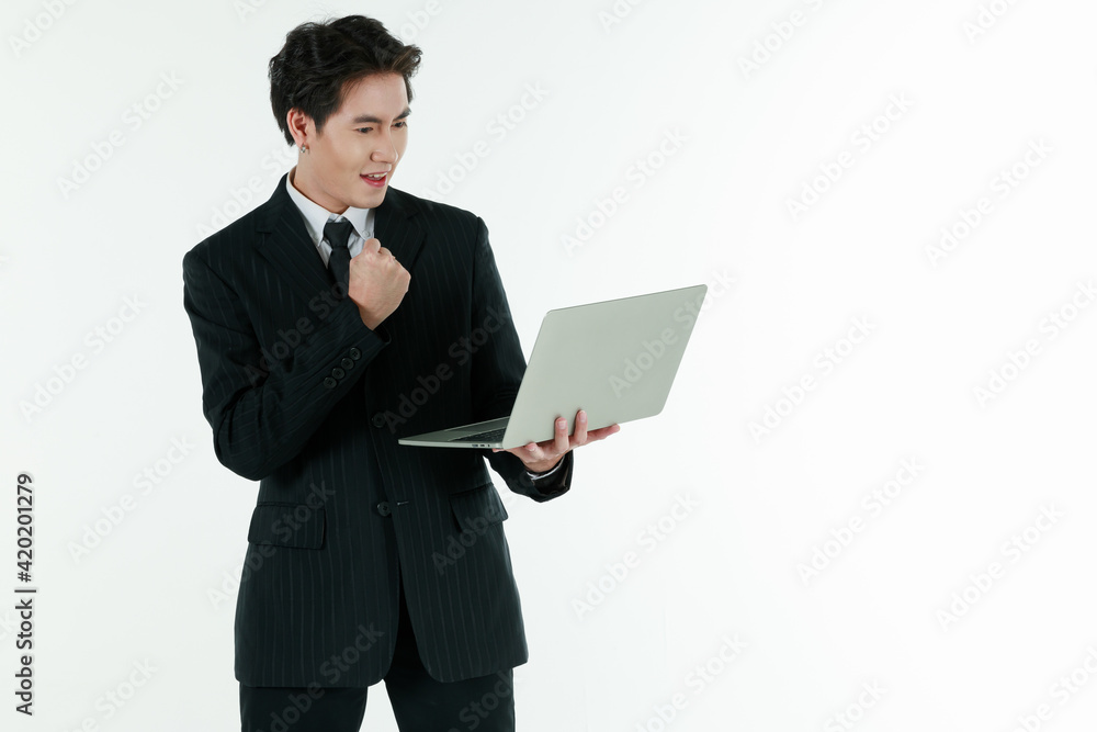 Portrait of self confidence young and handsome business Asian man in black suit holding notebook laptop computer with copy space studio shot isolated on white background Portrait of self confidence young and handsome business Asian man in black suit holding notebook laptop computer with copy space studio shot isolated on white background
