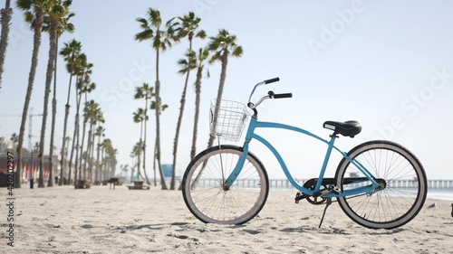 Fotografia Blue bicycle, cruiser bike by sandy ocean beach, pacific coast near Oceanside pier, California USA