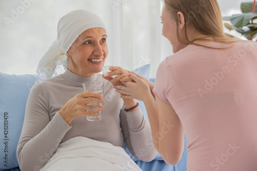 Fotografiet Daughter take medicine and glass of water to bring to female cancer patient who